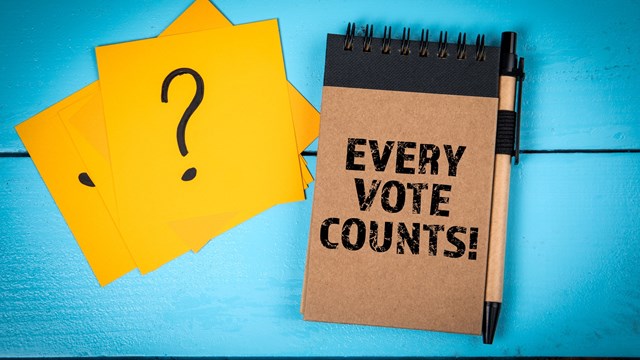 Every Vote Counts. Notebook, Pen, and Question Mark Cards on Blue Table.