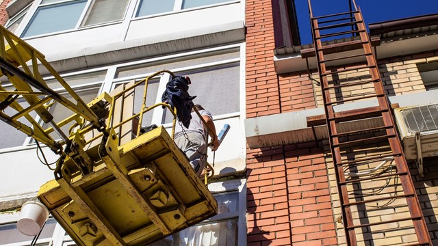 workers working with a car hydraulic lift, when working at high risk at altitude without an insurance rope, the front and rear background is blurred with a bokeh effect