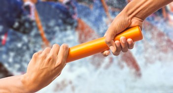 hands passing a relay baton on rowing team background and color tone effect.