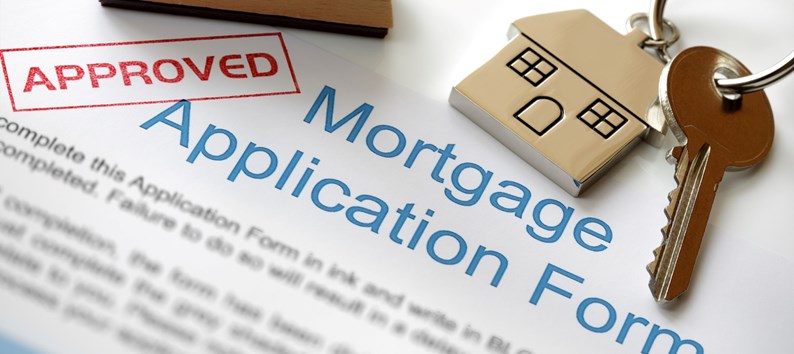 Approved Mortgage loan application with house key and rubber stamp