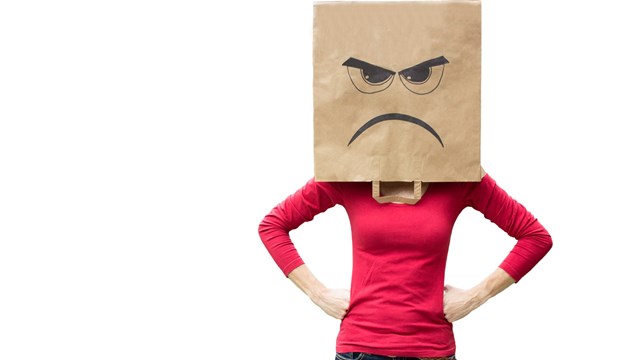 Woman with paper bag on her head with an angry expression on it