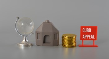 House model, coins, earth globe written with CURB APPEAL.Curb appeal refers to the visual attractiveness of a property, particularly its exterior or front-facing facade, as viewed from the street or sidewalk