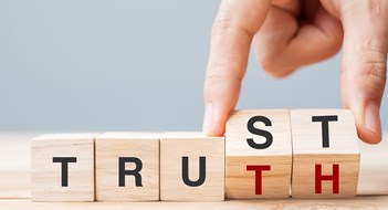 Business man hand change wooden cube block with TRUST and TRUTH business word on table background. Trustworthy, faith, beliefs and honesty concept