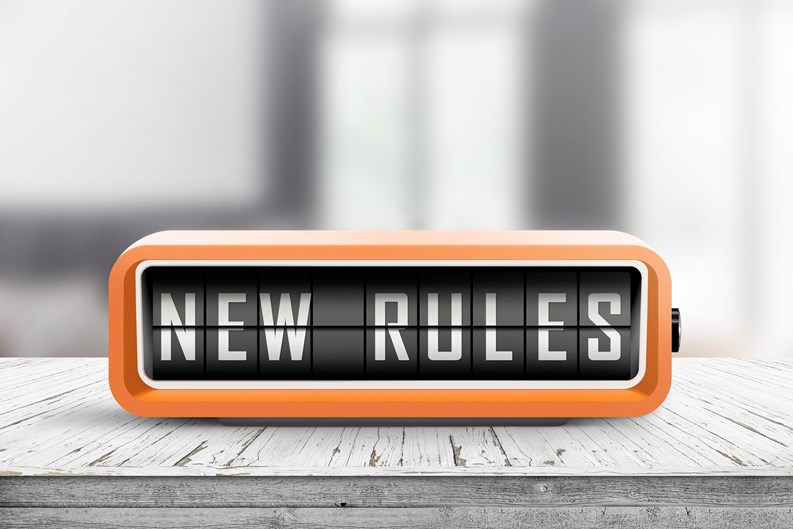 New rules alarm message on a wooden desk in a bright indoor environment