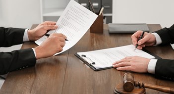 Responding to Litigation Law and justice. Lawyers working with documents at wooden table in office, closeup