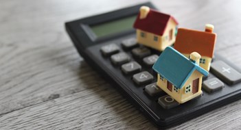 The Insurance Landscape Toy house and calculator with copy space. Property, home insurance, buy, sell and rent concept.