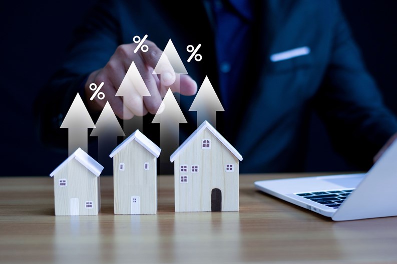 Businessman pointing at house icon with business growth percentage