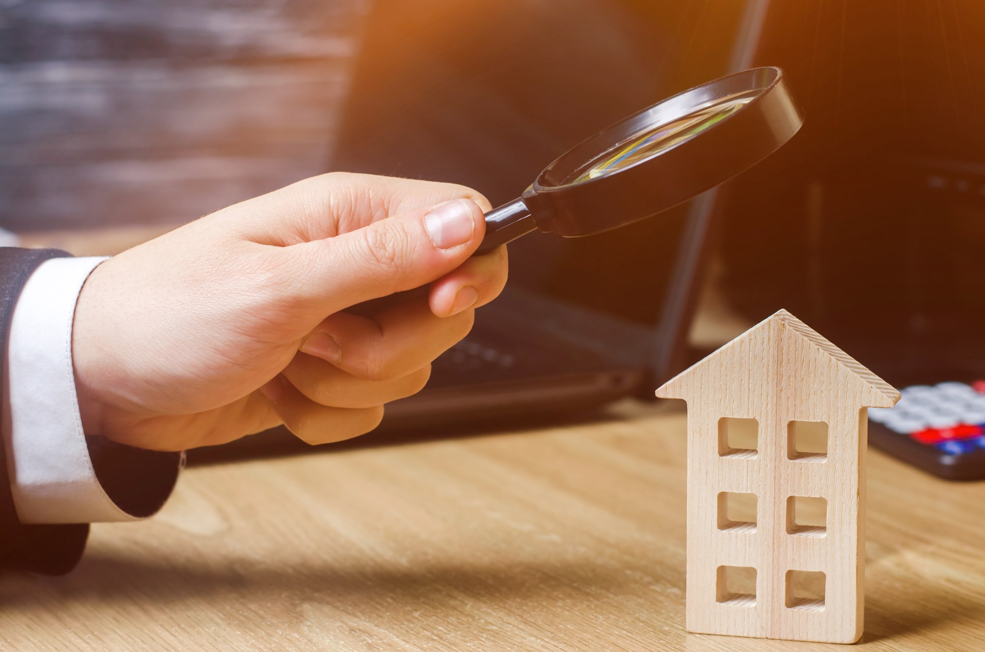 Wooden house and magnifying glass. Property valuation. Choice of location for the construction. House searching concept. Search for housing and apartments. Real estate concept. Home appraisal