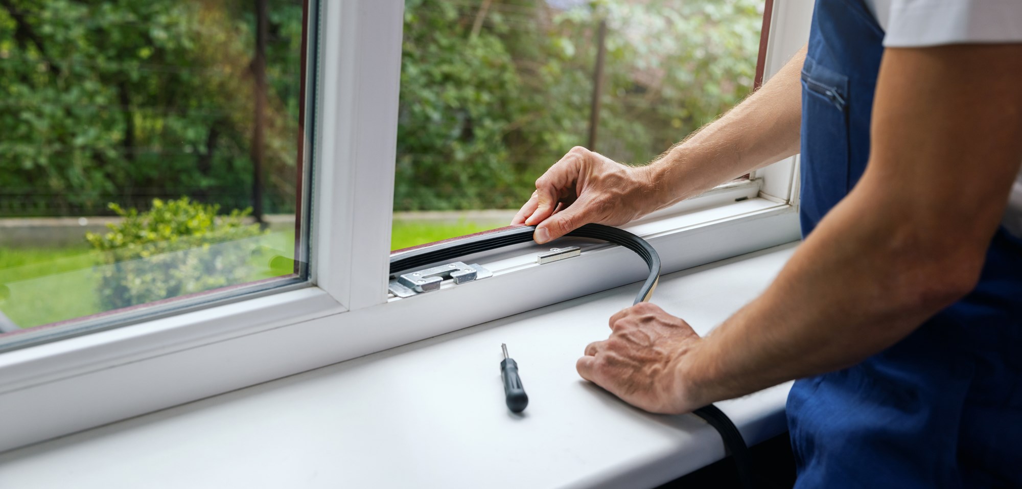 worker installing sealing tape on plastic window frame. banner with copy space